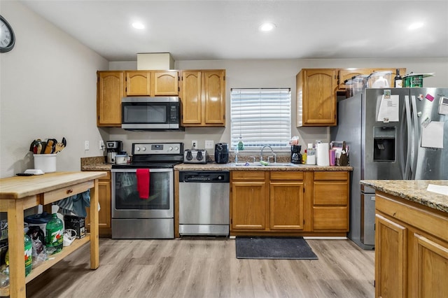 kitchen featuring a sink, recessed lighting, light wood-type flooring, and stainless steel appliances