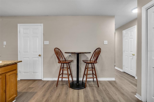 dining space with baseboards and wood finished floors