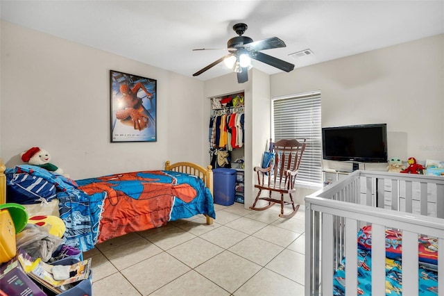 tiled bedroom with a ceiling fan, visible vents, and a closet