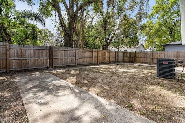 view of yard featuring a fenced backyard and central AC