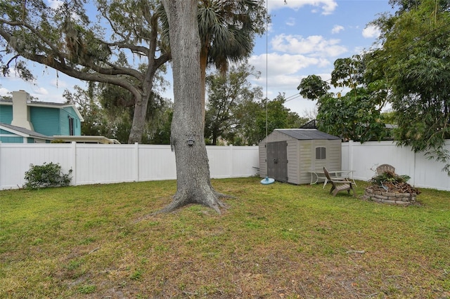 view of yard with an outdoor fire pit and a storage shed