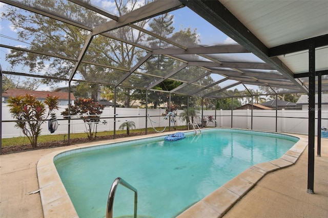 view of pool with a patio area and glass enclosure