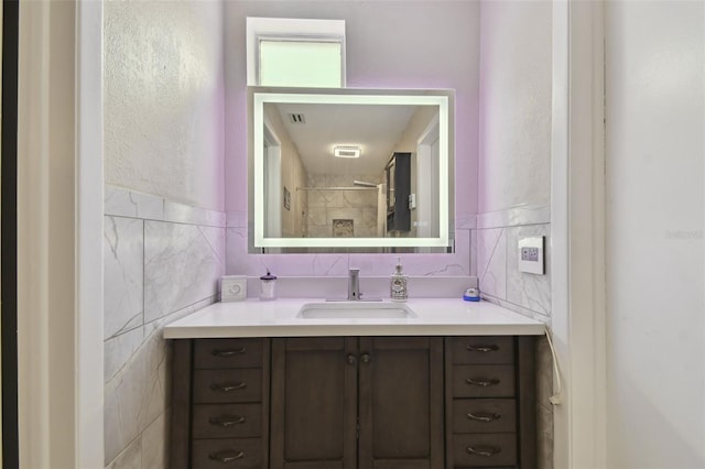 bathroom featuring vanity, tile walls, and a shower