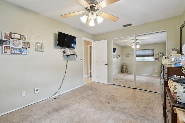 carpeted bedroom featuring a closet and ceiling fan