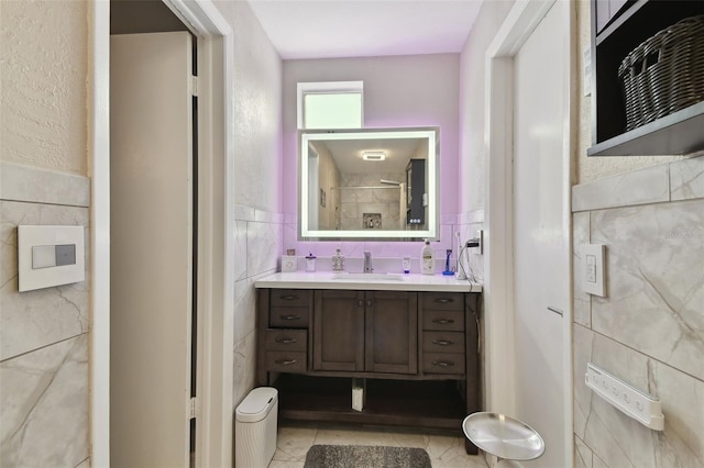 bathroom featuring vanity and tile walls