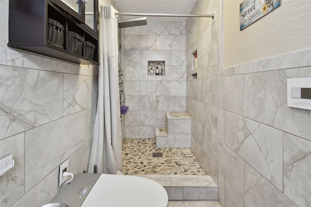 bathroom with toilet, curtained shower, and tile walls