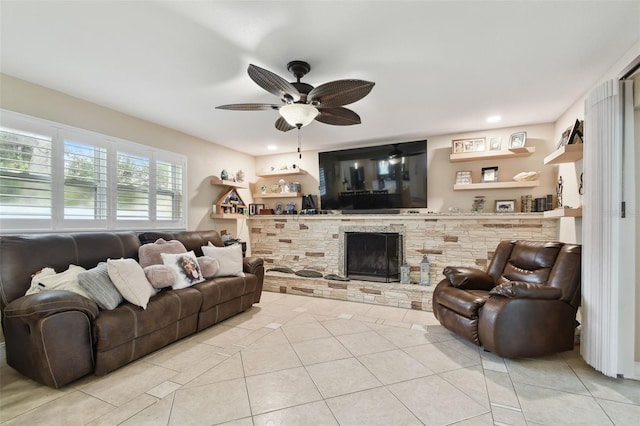 tiled living room with ceiling fan and a fireplace