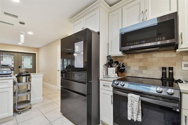 kitchen with stainless steel appliances, white cabinetry, and backsplash