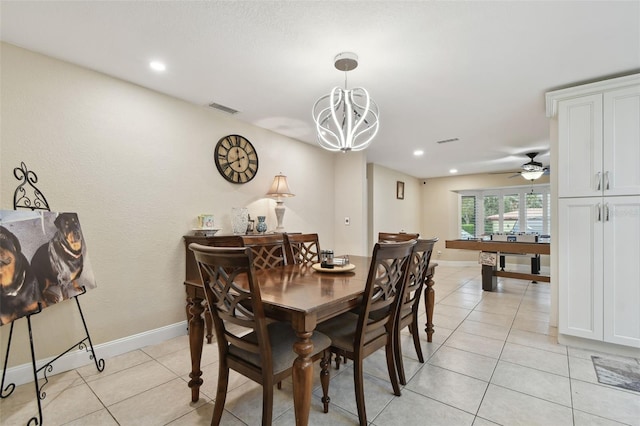 tiled dining room featuring ceiling fan with notable chandelier