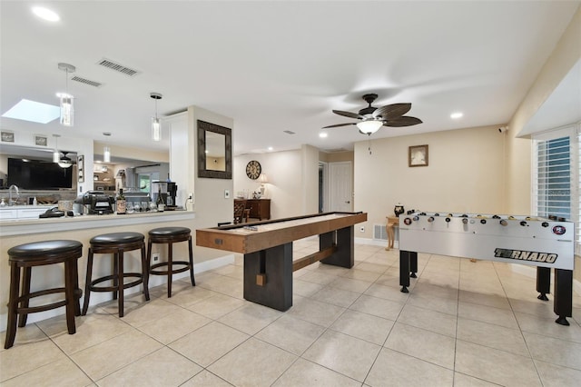 playroom featuring light tile patterned flooring, ceiling fan, and a skylight