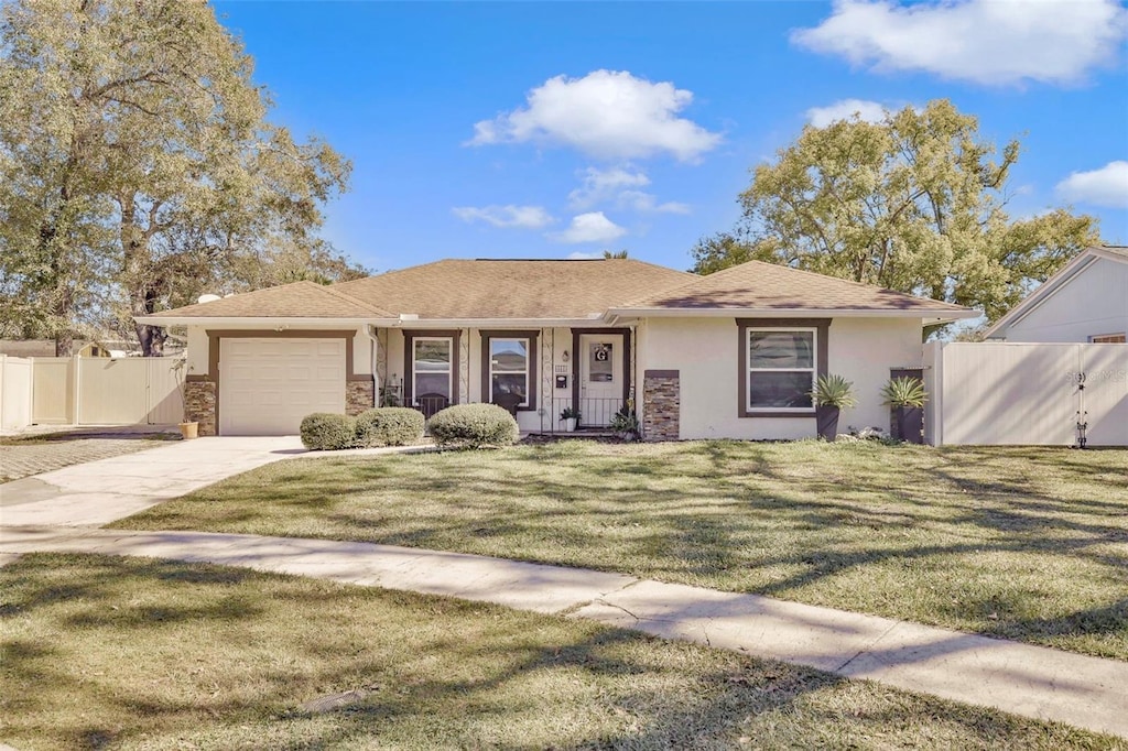 ranch-style house with a garage, covered porch, and a front yard