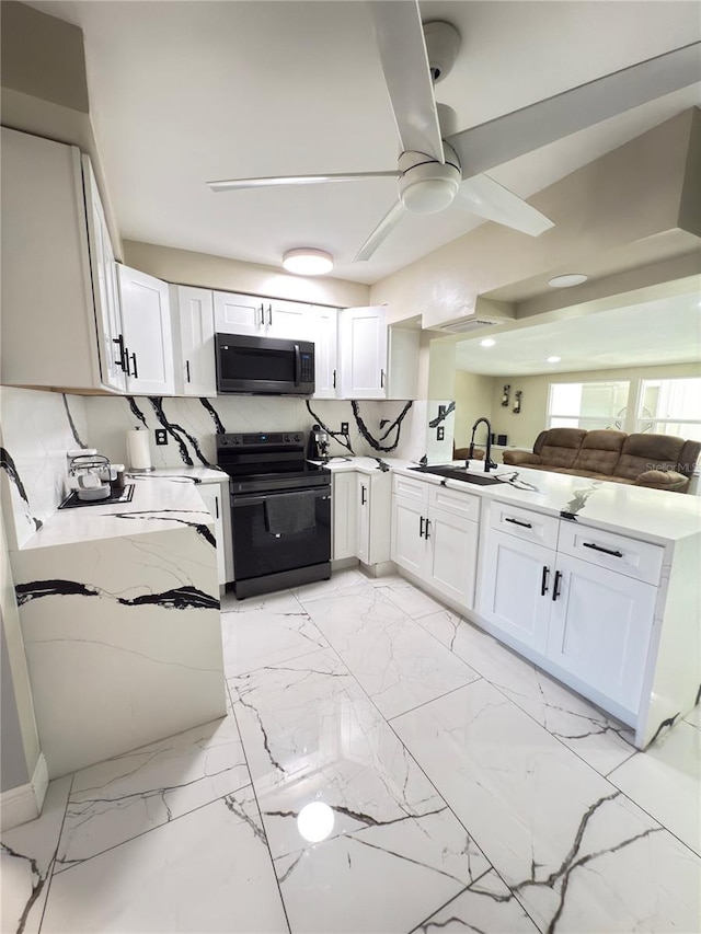 kitchen featuring ceiling fan, sink, black electric range, and white cabinets