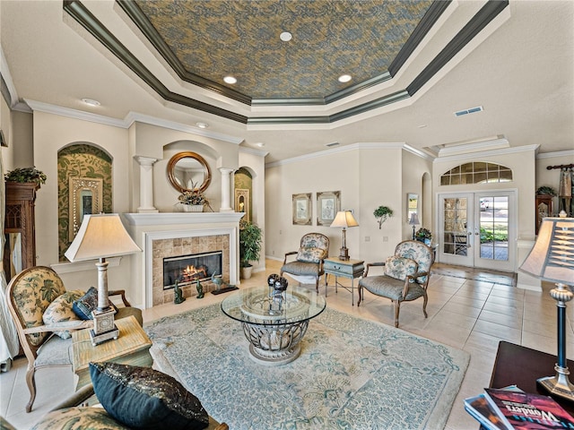 living area featuring visible vents, tile patterned flooring, a tray ceiling, french doors, and a fireplace