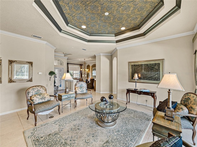 tiled living area with a tray ceiling, arched walkways, visible vents, a chandelier, and baseboards