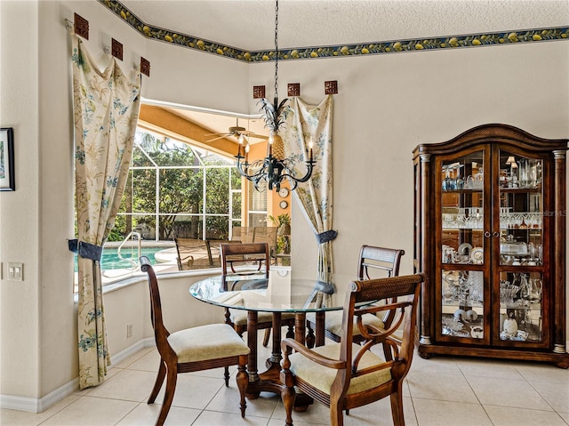 dining space with a sunroom, baseboards, a chandelier, and tile patterned floors