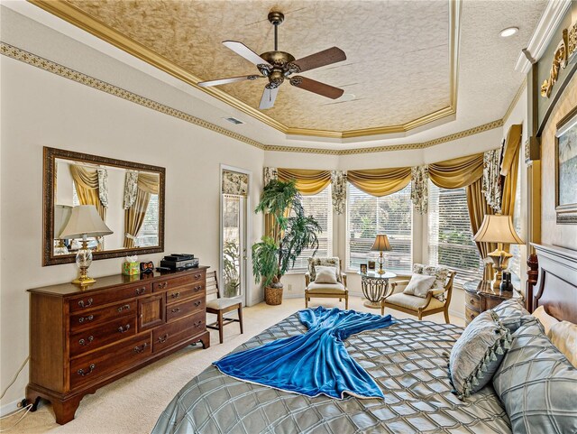 bedroom with ornamental molding, a tray ceiling, light carpet, and visible vents