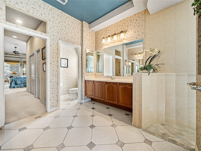 ensuite bathroom with toilet, vanity, ensuite bath, baseboards, and wallpapered walls