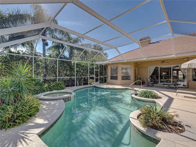 view of pool featuring a ceiling fan, a pool with connected hot tub, a patio area, and a lanai