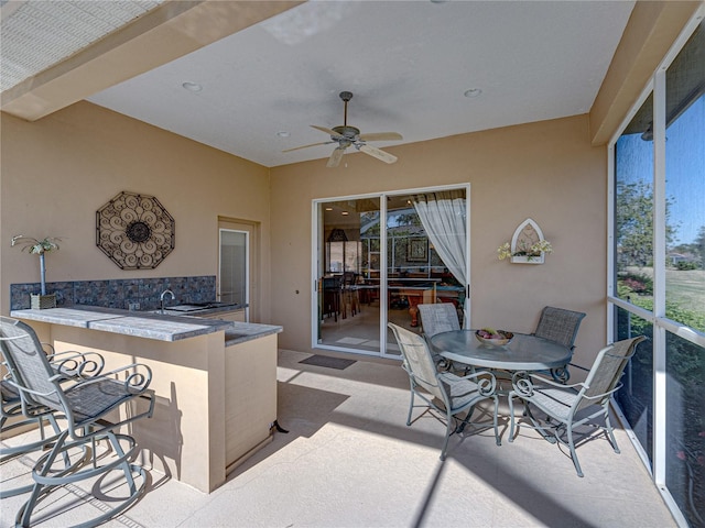 view of patio featuring a sink, outdoor dry bar, and a ceiling fan