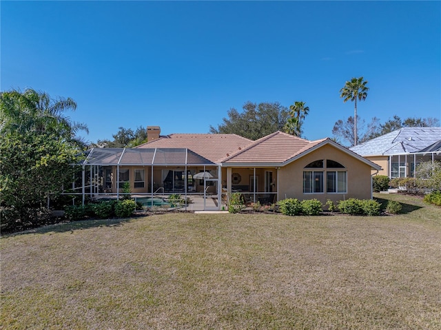 rear view of house with a chimney, stucco siding, a lawn, a lanai, and an outdoor pool