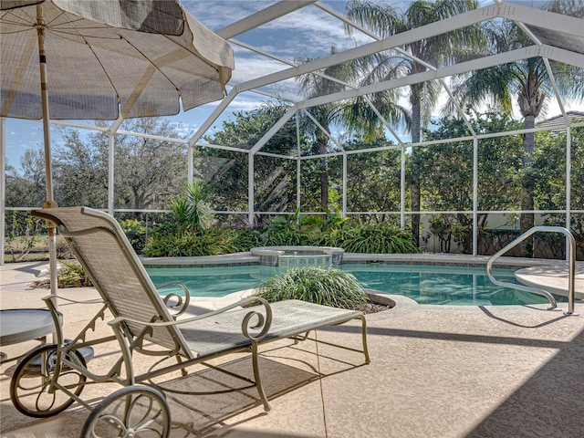 view of swimming pool featuring glass enclosure, a patio, and a pool with connected hot tub