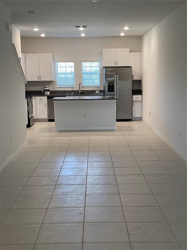 kitchen featuring sink, a kitchen island, white cabinets, and appliances with stainless steel finishes