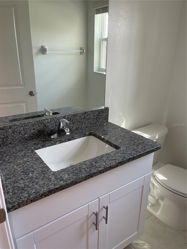 bathroom featuring vanity, tile patterned floors, and toilet