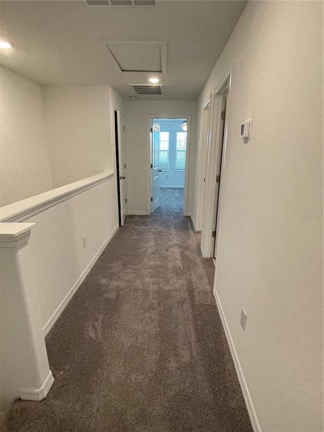 hallway featuring dark colored carpet