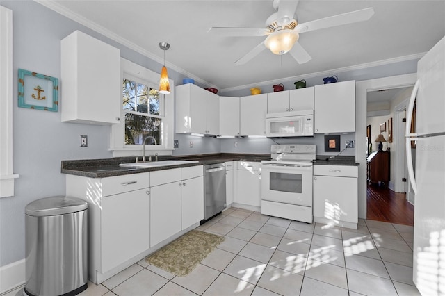 kitchen featuring sink, white cabinets, light tile patterned floors, crown molding, and white appliances