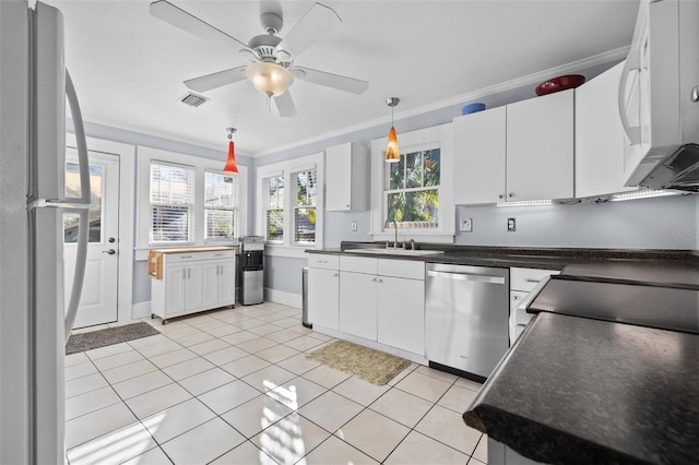 kitchen featuring light tile patterned flooring, sink, white cabinetry, crown molding, and appliances with stainless steel finishes