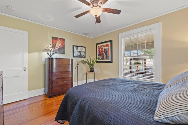 bedroom with crown molding, light hardwood / wood-style floors, and ceiling fan