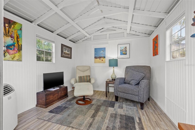 living area featuring lofted ceiling with beams and light hardwood / wood-style floors