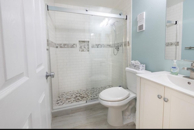 bathroom featuring vanity, toilet, and an enclosed shower