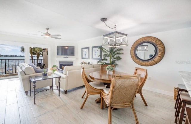 dining area featuring ceiling fan with notable chandelier and light wood-type flooring