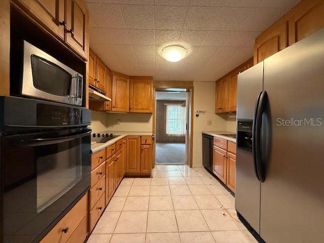 kitchen featuring light tile patterned floors and black appliances