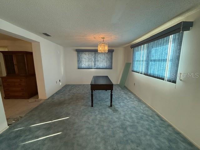 dining room with carpet floors and a textured ceiling