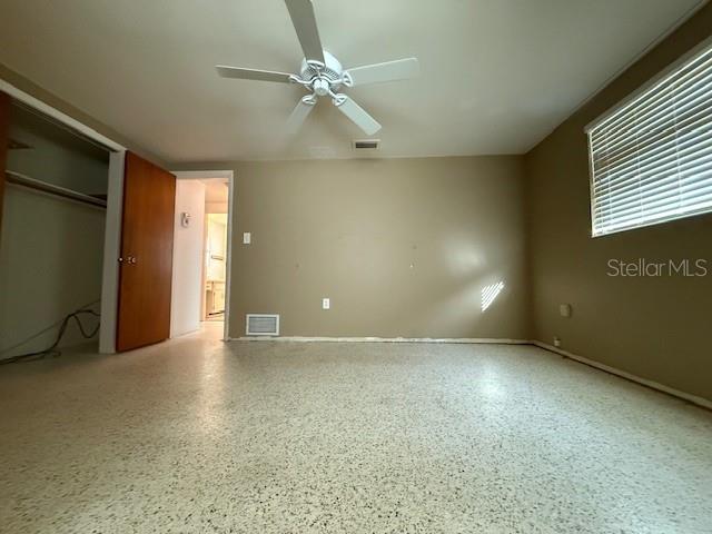 unfurnished bedroom featuring ceiling fan and a closet