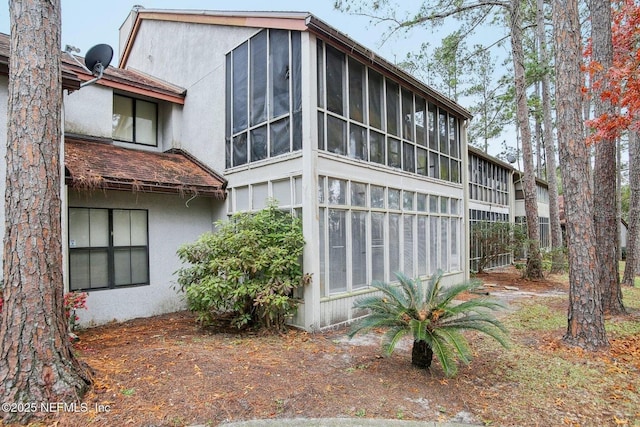 rear view of property featuring a sunroom