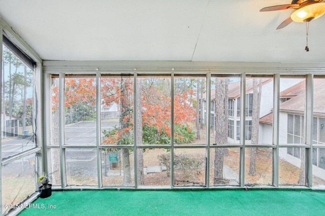 unfurnished sunroom featuring ceiling fan