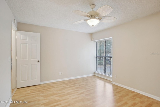 empty room featuring ceiling fan, a textured ceiling, and light wood-type flooring