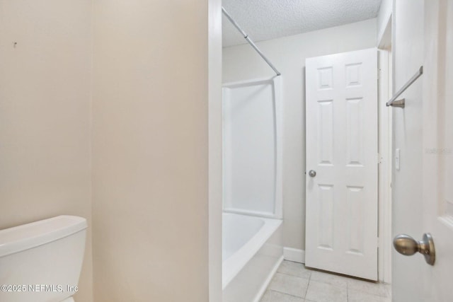 bathroom with tile patterned flooring,  shower combination, toilet, and a textured ceiling