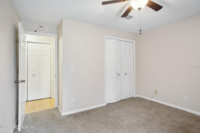 unfurnished bedroom with ceiling fan, a closet, a textured ceiling, and carpet flooring