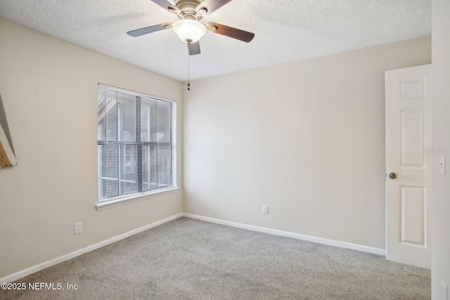 unfurnished room featuring ceiling fan, light carpet, and a textured ceiling