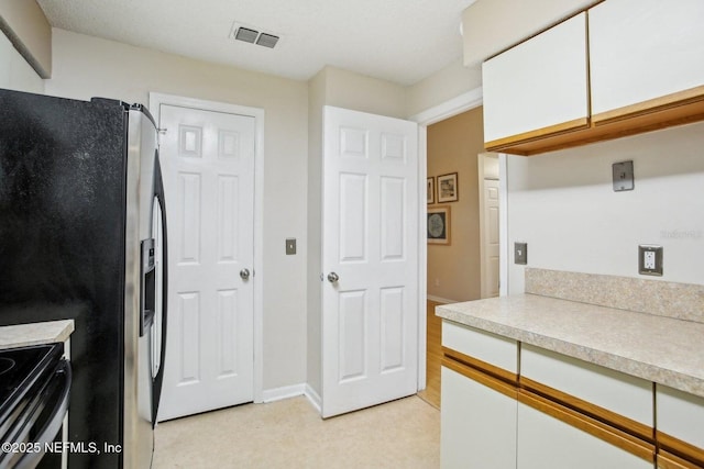 kitchen with white cabinetry and stainless steel refrigerator with ice dispenser