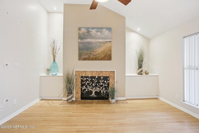 unfurnished living room with ceiling fan, lofted ceiling, hardwood / wood-style floors, and a fireplace