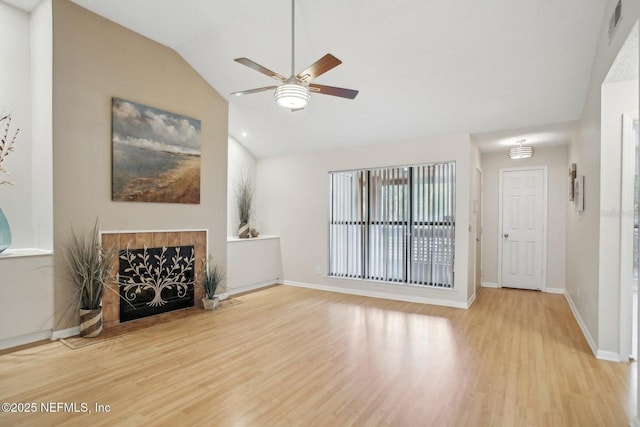 living room featuring a tiled fireplace, hardwood / wood-style flooring, lofted ceiling, and ceiling fan