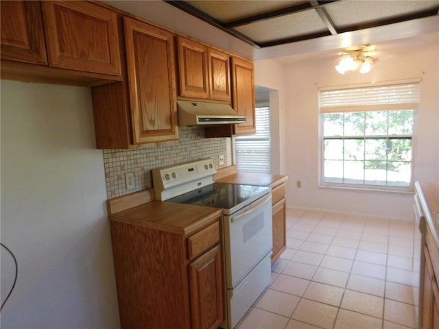 kitchen featuring light tile patterned flooring, decorative backsplash, and electric stove