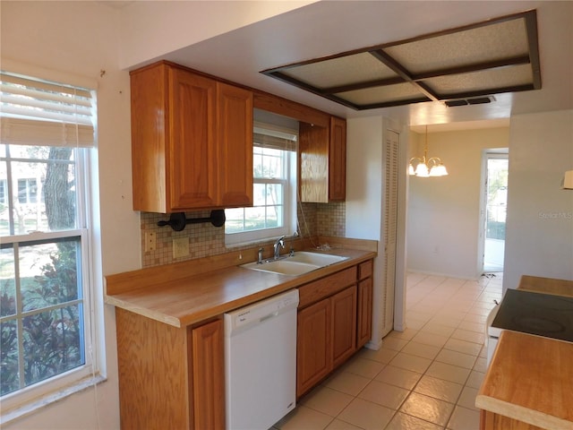 kitchen with white dishwasher, sink, decorative light fixtures, and decorative backsplash