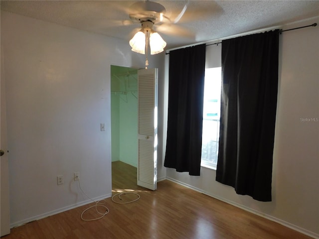 spare room featuring hardwood / wood-style flooring, ceiling fan, and a textured ceiling