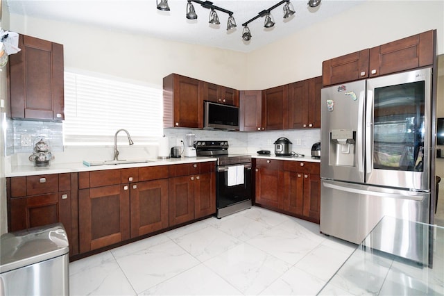 kitchen featuring dark brown cabinetry, appliances with stainless steel finishes, sink, and backsplash